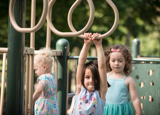 Young female student on monkey bars at the playground