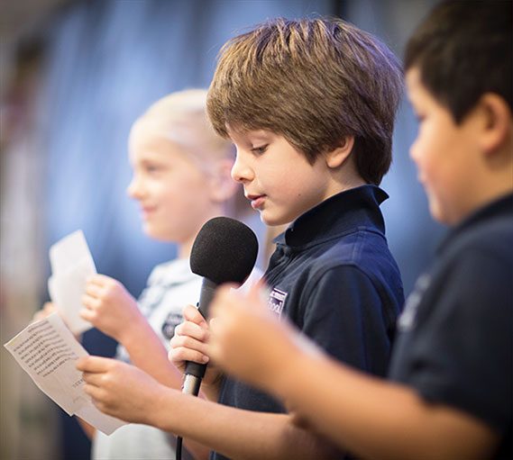 Male student reading something over the microphone